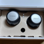 **

A close-up shot of a "brand new" Bluetooth earphone box. The box is slightly damaged, with a torn plastic seal and minuscule scratches near the charging port, highlighting the hidden flaws despite the "new" claim. Use a magnifying glass overlay effect on the scratches.

**
