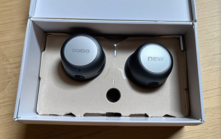 **

A close-up shot of a "brand new" Bluetooth earphone box. The box is slightly damaged, with a torn plastic seal and minuscule scratches near the charging port, highlighting the hidden flaws despite the "new" claim. Use a magnifying glass overlay effect on the scratches.

**